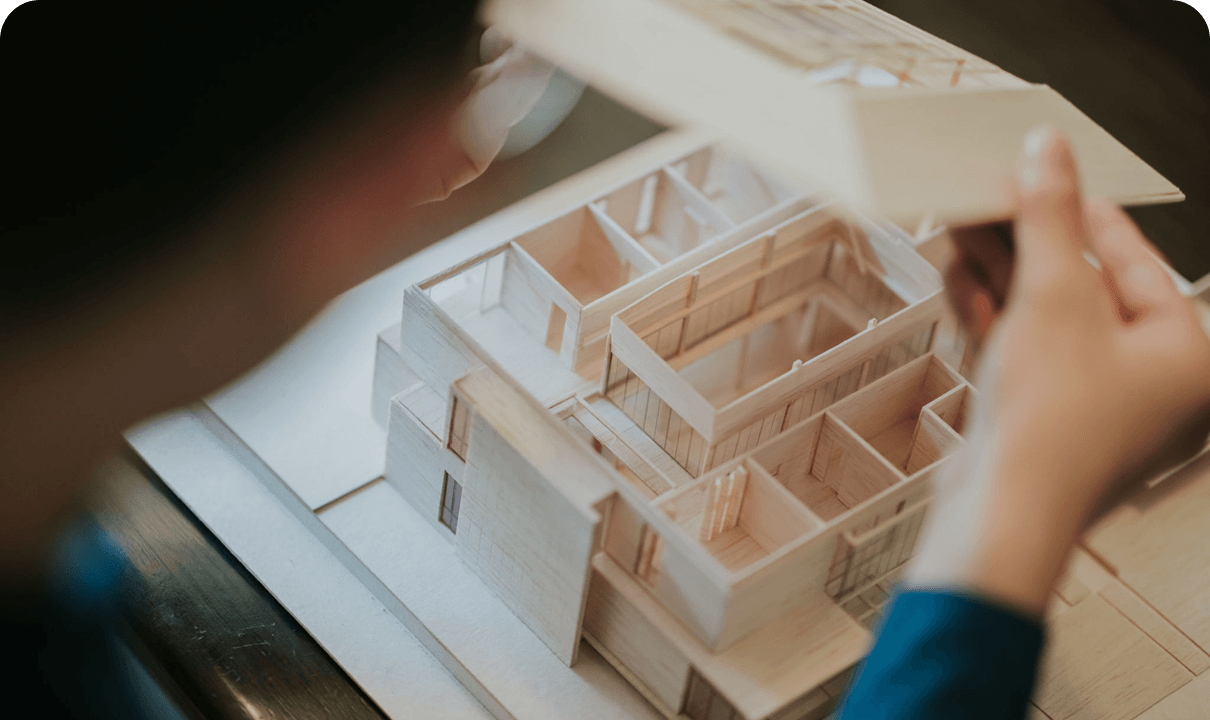 Architect examining wooden house model