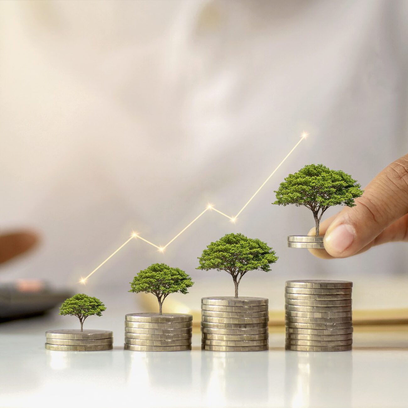 A businessman holding a coin with a tree that grows and a tree that grows on a pile of money. The idea of maximizing the profit from the business investment.